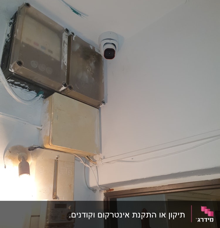קופסת חשמל עם חוטים ליד מצלמת אבטחה
